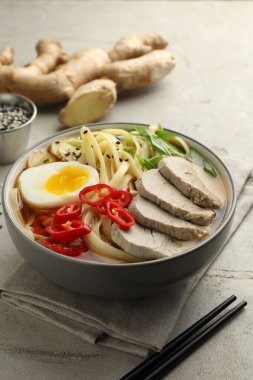 Kasede lezzetli ramen ve hafif desenli masada çubuklar, yakın plan. Erişte çorbası.