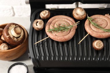 Ev yapımı sosis, biberiye ve mantarlı elektrikli ızgara.