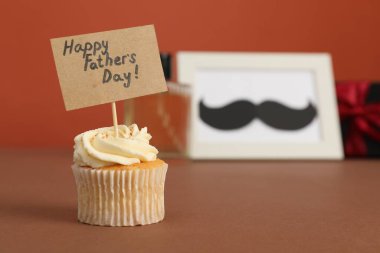Babalar Günün kutlu olsun. Kahverengi masada selamları olan lezzetli bir kek, yakın plan. Metin için boşluk