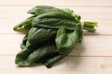 Hafif ahşap masada taze ıspanak yaprakları, yakın plan.