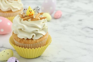 Lezzetli paskalya keki, vanilya kremalı ve beyaz mermer masa üzerinde şekerler, metin için yer var.