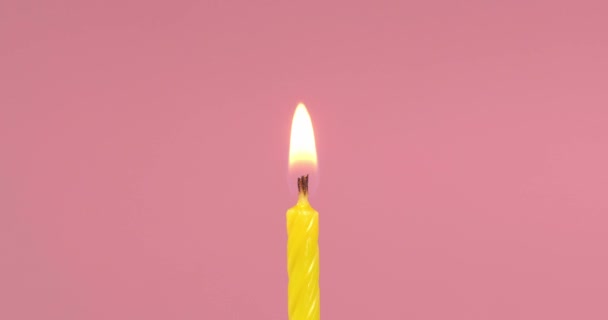 在粉色背景上吹灭黄色节日蜡烛 — 图库视频影像