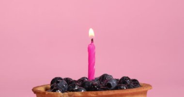 Pembe arka planda yanan şenlikli yaban mersinli tart, yakın plan.