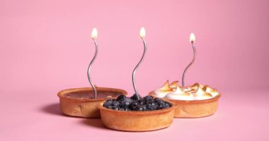 Pembe arka planda gümüş renkli mumlar yakan farklı fahişeler.