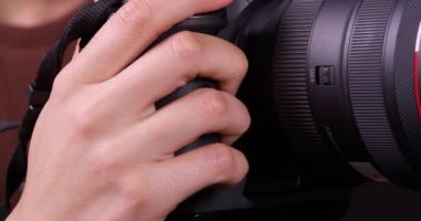 Lviv, Ukrayna - 20 Ağustos 2022: Canon EOS R5 kamerasını üç ayaklı objektifle döndüren fotoğrafçı, yakın plan