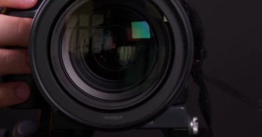 Lviv, Ukrayna - 20 Ağustos 2022: Canon EOS R5 kamerasını üç ayaklı objektifle döndüren fotoğrafçı, yakın plan