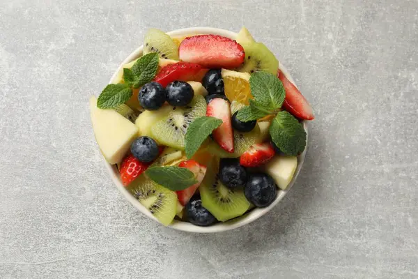 Tasty Fruit Salad Bowl Gray Textured Table Top View — Stock Photo, Image