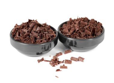 Beyazlar üzerinde izole edilmiş kâselerdeki lezzetli çikolata parçaları.