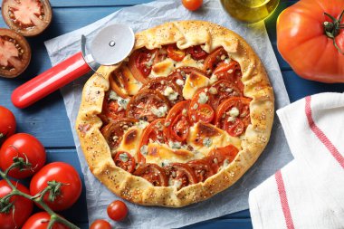 Mavi ahşap masa üzerinde domates ve peynirli (Caprese galette) leziz galette düz bir bileşim yatıyordu