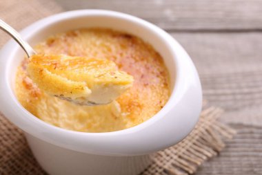 Sofrada kaşıkla leziz bir creme brulee alıp, yakın plan.