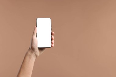 Elinde bej arka planda boş ekranlı akıllı telefon tutan adam, yakın plan. Tasarım için model