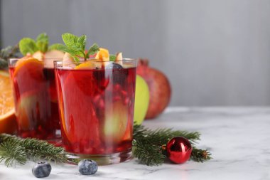Beyaz mermer masada, bardaklarda, malzemelerde ve Noel dekorunda Aromatik Sangria içeceği, metin için yer