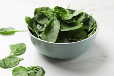 Beyaz masada taze ıspanak yaprakları, yakın plan.