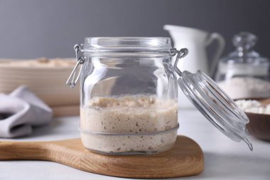 Ekşi hamur başlatıcı cam kavanozda Işık masasında, yakın plan