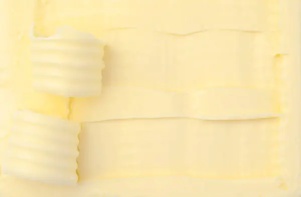 Tasty butter and curls as background, top view