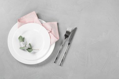 Gri masadaki şık çatal bıçak seti, üst manzara. Metin için boşluk