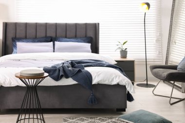 Şık bir yatak odasında, yatakta parlak ekose. İç tasarım