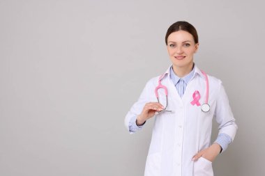 Gri arka planda pembe kurdeleli Mammolog, mesaj için yer var. Göğüs kanseri farkındalığı