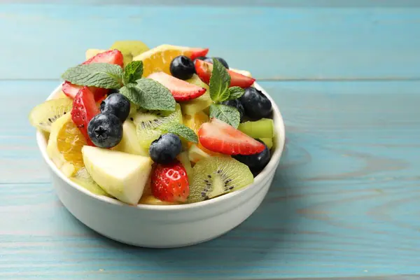 Tasty Fruit Salad Bowl Light Blue Wooden Table Closeup Space — Stock Photo, Image