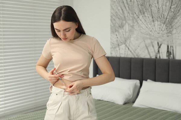 Диабет. Женщина делает инъекцию инсулина в живот в спальне, место для текста
