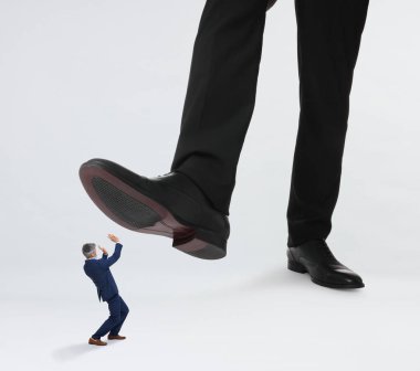 Beyaz arka planda küçük bir adamın üzerine büyük bir adım