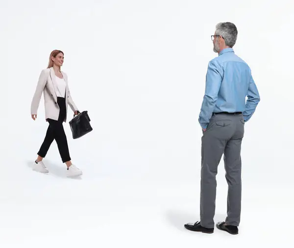 Small woman walking towards to giant man on white background