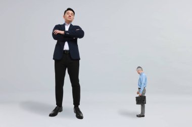 Dev patron ve arka planda üzgün küçük adam.