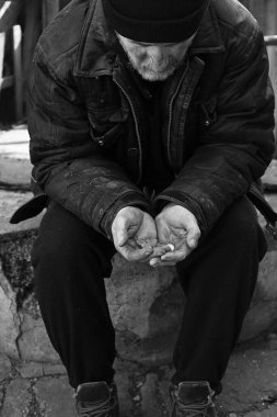 Zavallı evsiz yaşlı adam dışarıda bozuk para tutuyor. Siyah ve beyaz etkisi