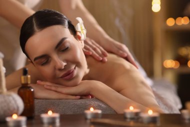 Spa terapisi. Salondaki masaj sırasında masada uzanan güzel genç bir kadın.