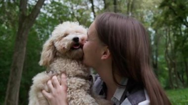 Şirin köpeğiyle parkta dinlenen bir kadın, yakın plan.