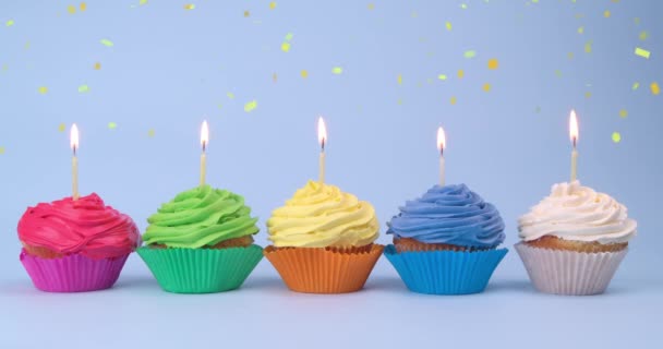 Födelsedag Cupcakes Med Ljus Ljusblå Bakgrund Fallande Konfetti Effekt — Stockvideo
