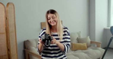 Genç, güzel, profesyonel fotoğrafçı modern kamerayla fotoğraf çekiyor.