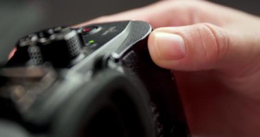Kamerayı ayarlayan ve bulanık arkaplanda fotoğraf çeken fotoğrafçı, yakın plan
