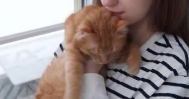 Evinde sevimli turuncu kedisiyle bir kız.