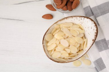 Taze badem gevrekleri ve fındıklar beyaz ahşap masada, düz yerde. Metin için boşluk