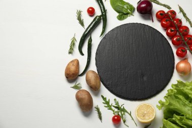 Yemek pişiriyorum. Siyah kesme tahtası ve beyaz ahşap masa üzerinde farklı ürünler, düz yatıyordu. Metin için boşluk