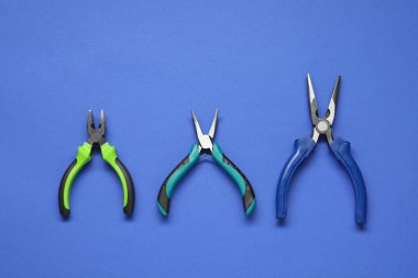 Mavi arka planda farklı pense, düz yatış