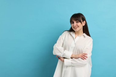 Açık mavi arka planda pijama giyen mutlu kadın, metin için boşluk
