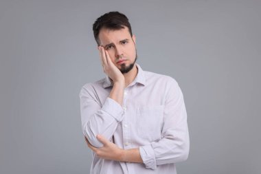 Gri arka planda üzgün bir adamın portresi