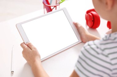E-öğrenme. Tablet kullanan kız çevrimiçi çalışmak için kapalı masa, yakın çekim
