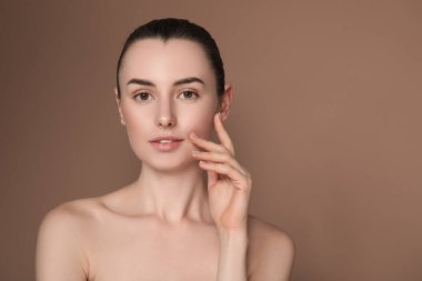 Kahverengi arka planda güzel bir genç kadının portresi. Metin için boşluk