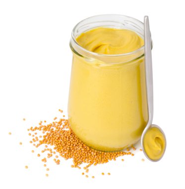 Cam kavanoz ve bir kaşık lezzetli hardal sosu. Kuru tohumlar beyaz üzerine izole edilmiş.