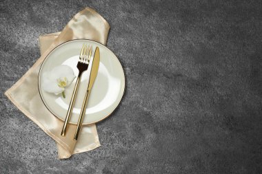 Gri masadaki şık çatal bıçak seti, üst manzara. Metin için boşluk