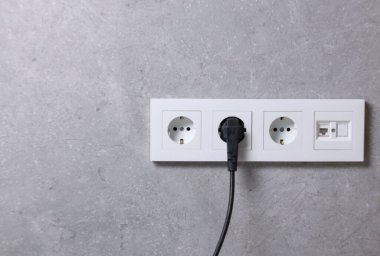 Gri duvarda prizler ve elektrik prizleri, metin için boşluk
