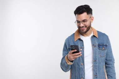 Beyaz arka planda akıllı telefon kullanan mutlu genç adam, mesaj için boşluk