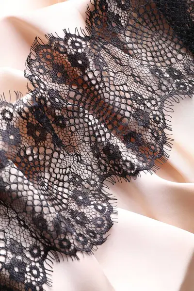 Beautiful black lace with pattern on beige fabric