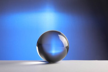 Masada mavi zemin üzerinde şeffaf cam top