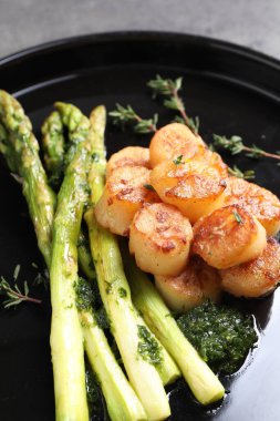 Kuşkonmaz ve kekik kaplı lezzetli kızarmış midyeler, yakın plan.