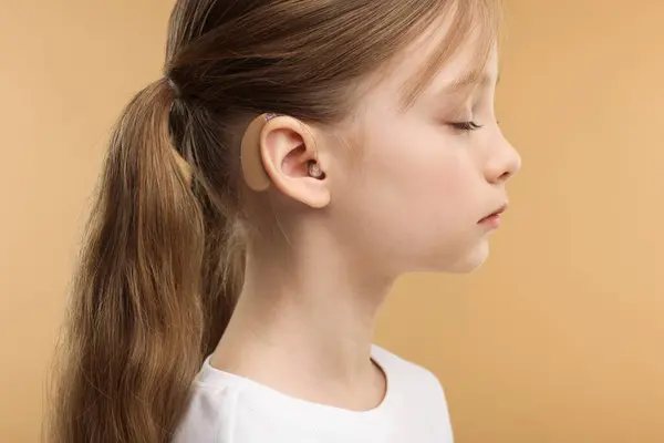 Little Girl Hearing Aid Pale Brown Background Closeup — Stock Photo, Image