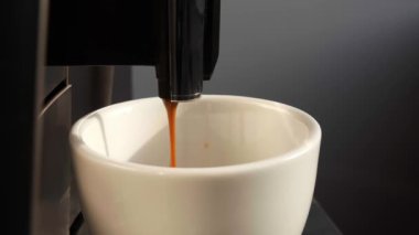 Modern kahve makinesi beyaz fincana espresso yapıyor, yakın plan.
